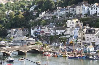 a group of boats in a harbor with a bridge at Polmear Harbour View With Terrace in Looe