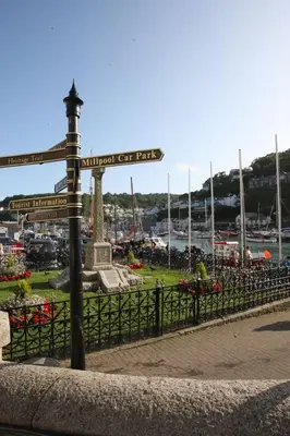 a pole with street signs on it next to a park at Lanescot, Harbour View With Terrace in Looe