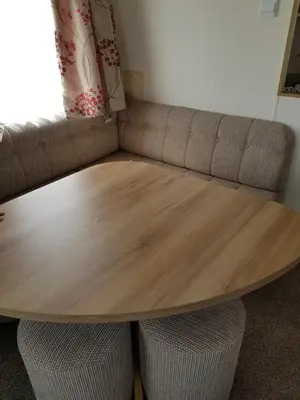 a wooden table with two chairs and a couch at Caravan Willerby Gold Star in Looe
