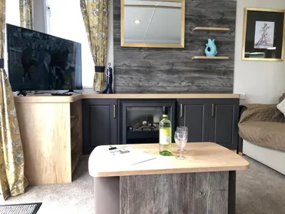a living room with a table with a bottle of wine at Newquay Blue Water in Newquay