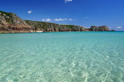 a large body of water next to a rocky coastline at Newquay Blue Water in Newquay