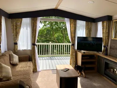 a living room with a couch and a large window at Newquay Blue Water in Newquay