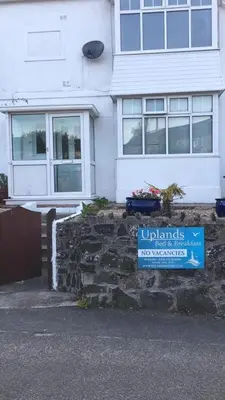 a house with a blue sign in front of it at Uplands B and B in St Ives