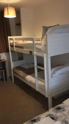 two white bunk beds in a room at Uplands B and B in St Ives