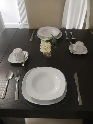 a black table with plates and utensils on it at Uplands B and B in St Ives