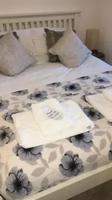 a bed with two towels and pillows on it at Uplands B and B in St Ives