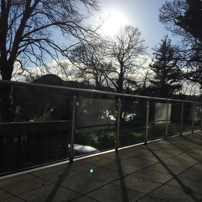 a view of a fence with the sun behind it at The Apartment Boscawen Woods in Truro