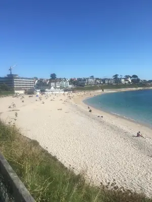 a beach with a bunch of people in the water at 'the inlet' falmouth in Falmouth