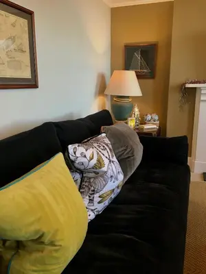 a black couch with a pillow on it in a living room at 'the inlet' falmouth in Falmouth