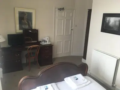 a hotel room with a desk and a chair and a door at The White Hart Hotel in Hayle