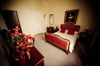 a bedroom with a bed and a couch and flowers at The White Hart Hotel in Hayle