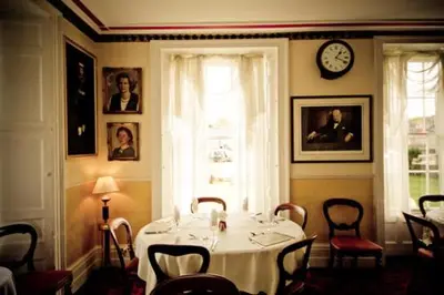 a dining room with a table and a clock on the wall at The White Hart Hotel in Hayle