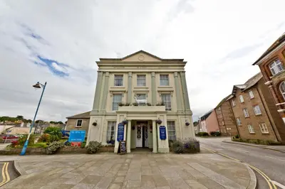 a large white building on the corner of a street at The White Hart Hotel in Hayle