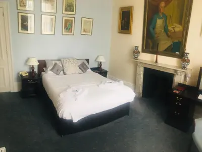 a bedroom with a large bed and a fireplace at The White Hart Hotel in Hayle
