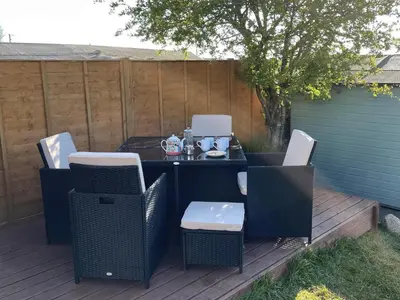 a patio with a table and chairs on a deck at Moor View in Delabole