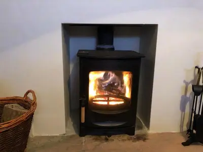 a black stove with a fire in a room at Moor View in Delabole