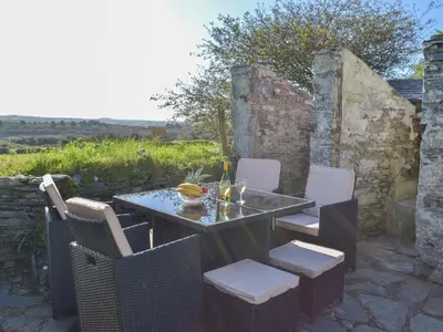 a table and chairs on a stone patio at Moor View in Delabole