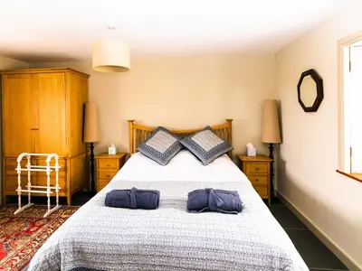 a bedroom with a large bed with two pillows at Rosecott in St Ives