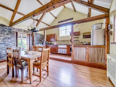 a kitchen with a wooden table and chairs at Provence-Uk12747 in Menheniot