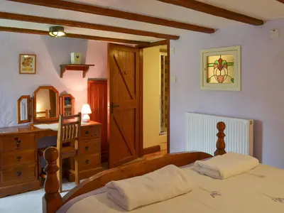 a bedroom with a bed and a dresser and a mirror at Provence-Uk12747 in Menheniot