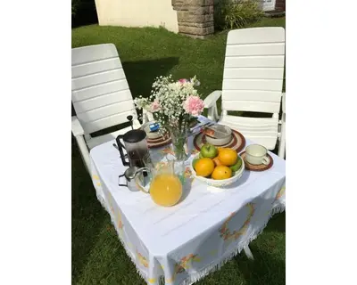 a table with a bowl of fruit and flowers on it at Villa 7 Lanteglos, Camelford, Cornwall in Camelford