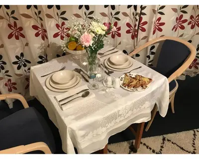 a white table with a plate of food and flowers on it at Villa 7 Lanteglos, Camelford, Cornwall in Camelford