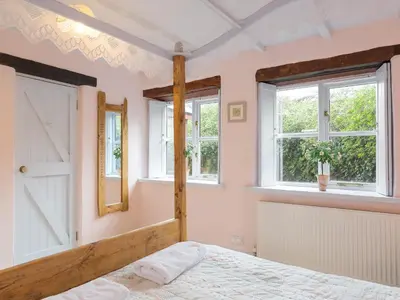a bedroom with a bed and two windows at New England-Uk12750 in Menheniot