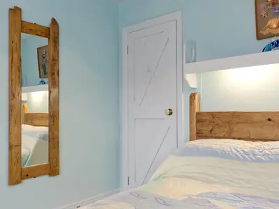 a bedroom with a bed and a mirror at New England-Uk12750 in Menheniot