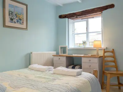 a bedroom with a bed and a desk and a window at New England-Uk12750 in Menheniot