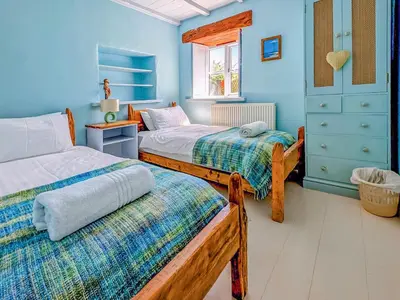 two beds in a room with blue walls at New England-Uk12750 in Menheniot