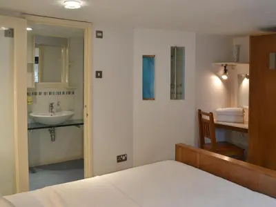 a bedroom with a bed and a bathroom with a sink at Moderno-Uk12748 in Menheniot