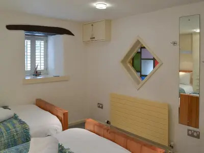 a bedroom with two beds and a mirror at Moderno-Uk12748 in Menheniot