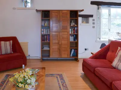 a living room with two red couches and a book shelf at Moderno-Uk12748 in Menheniot