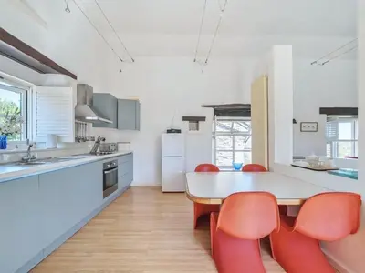 a kitchen with a table and red chairs at Moderno-Uk12748 in Menheniot
