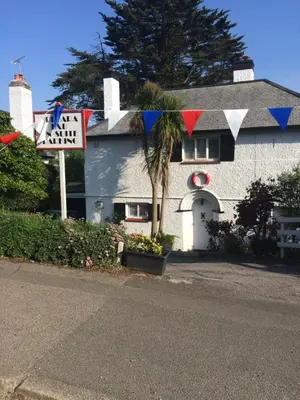 a white house with a palm tree in front of it at Tredara Bed & Breakfast in Truro