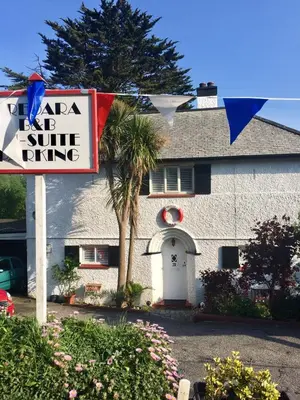 a sign in front of a house with a sun shining at Tredara Bed & Breakfast in Truro