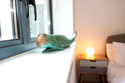 a small statue of a bird sitting on a window sill at Fowey Landing in Fowey