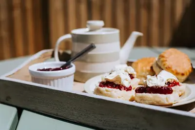 a plate of pastries with jam and cream on a table at Sunset in Newquay