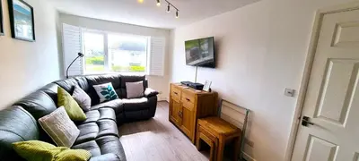 a living room with a leather couch and a table at 2 Rosemullion in Perranporth