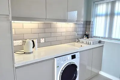 a kitchen with a washing machine and a sink at 2 Rosemullion in Perranporth