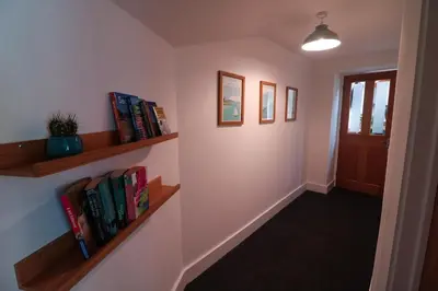 a hallway with shelves of books and a door at The Wood Shed in Truro