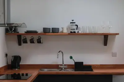 a kitchen with a sink and wooden counter top at The Wood Shed in Truro