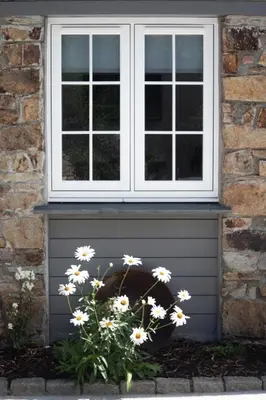 a window and a bunch of white flowers in front of a house at The Wood Shed in Truro
