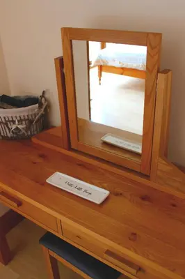 a mirror on top of a wooden table at Hooters Apartment EV Point in Wadebridge