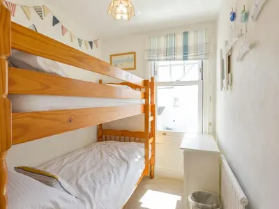 a bedroom with two bunk beds and a window at Beachcomber in Padstow