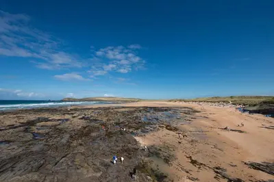 a group of people standing on a beach at Beachcomber in Padstow