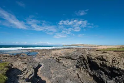 a view of a beach with rocks and the ocean at Beachcomber in Padstow