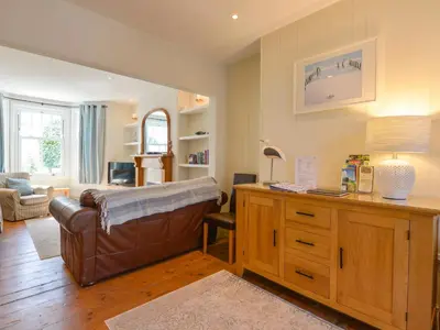 a living room with a leather couch and a desk at Beachcomber in Padstow