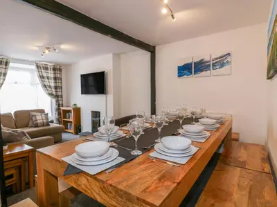 a dining room with a wooden table with plates and wine glasses at Fistral Quay in Newquay