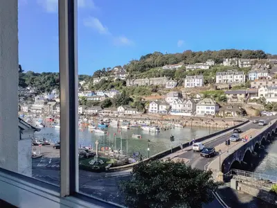 a window view of a harbor with boats in the water at Harbour View Apartment in Looe